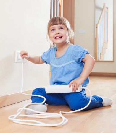 Child playing with electric outlet - Are your children safe from toxic substances - Spivey Law Firm, Personal Injury Attorneys, P.A.